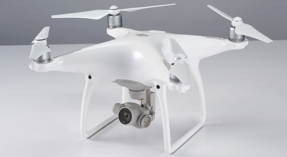 The Phantom 4 has several features to help new pilots, including auto takeoff and landing, and you can set features such as beginner mode, which limits the Phantom 4's flight speed and distance from the home point. You can also find a comprehensive set of videos and tutorials on the DJI website.There are several flight features that will appeal to photographers, including the ActiveTrack flight mode. This enables a subject to be selected on the screen, which the drone will then follow automatically – it's ideal for extreme sports such as mountain biking or water skiing, as the drone can film without the need for an additional pilot.Intelligent flight options also enable you to set points of interest – once selected the drone will circle that point. There are also more common commands, such as Follow Me and waypoints. Waypoints have been around for a while in drones, and enable you to plot your flight route from one point to another.If you're using one of the new intelligent flight modes – TapFly, ActiveTrack or Smart Return Home – the object avoidance feature will cause the Phantom 4 to either stop or fly around the object; all very clever.Another nice touch within the Object Avoidance options is Backwards Flying, which makes the drone literally back up when approached from the front – although we obviously wouldn't advise approaching a drone from the front to try this out.TouchFly is another new feature, and enables you to fly the Phantom by just tapping the screen; this takes a while to get used to, especially if you're used to using a handset and control sticks, but it enables you to concentrate on getting your shots or footage, rather than keeping the drone in the air.I found that object avoidance worked well, with the Phantom 4 stopping short of objects in its path. It should be noted that before the test I was warned not to test the object avoidance through trees early in the year, as the system has issues with trees without leaves.When an object is detected the controller first sends out an audible warning before the drone stops mid-flight. There are several different object avoidance options, which can be switched between quickly by touching the sensor icon at the top of the apps interface.As with the Phantom 3, standard flight is incredibly easy, even in gusty conditions. This means that anyone, even if completely new to flying, should be able to pick up the handset and successfully fly the Phantom 4, although again you should familiarise yourself with the regulations issued by the aviation authorities in the country where you're flying, and we'd also recommend taking an approved training course.Video captureThe small mechanical gimbal that stabilises the camera in flight is impressive, and even when the drone is being battered by wind, the footage captured by the camera remains steady.Photographers will find the Lightbridge live view technology a real benefit. This is capable of beaming a 720HD video signal across a distance of 1.2 miles, although 500m (or less – you must always be able to see the drone) is the maximum legal distance allowed between you and your drone under UK law; different regulations apply in other countries, so be sure to check.The live view stream between the drone and app is virtually instant, with only the slightest delay noticeable.Video quality is excellent – colours are bright, and the contrast level gives footage punch and crispness. In bright conditions the image is clear and sharp at all resolutions; however, as is common with cameras of this size, when the light falls the quality of the footage quickly deteriorates, and noise starts to become apparent.When the light dipped I found it was well worth switching the video to manual in order to improve the quality of footage, rather than relying on the auto settings.Footage at 1080p at both 60fps and 120fps is smooth, as long as the light is good. As the frame rate increases the bitrate for each frame reduces and definition drops. At 30fps and 60fps the quality of the video is exceptional; however once the frame rate is upped to 120fps quality drops dramatically, especially in overcast conditions.DJI has worked on the lens to ensure distortions are kept to a minimum, so footage doesn't exhibit the fish-eye look that's common with action cameras such as the GoPro Hero4 Black.Flying qualificationsIf you're looking to fly any drone for commercial use you need a licence, and this is applicable in all countries. In the UK this licence is issued through the CAA and called a Permission for Aerial Work (Pfaw).DJI Phantom 4 review