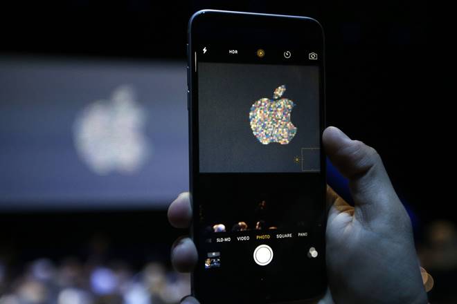 A guest takes a photo of the Apple logo at the Apple Worldwide Developers Conference in the Bill Graham Civic Auditorium, Monday, June 13, 2016, in San Francisco. (AP Photo/Tony Avelar)